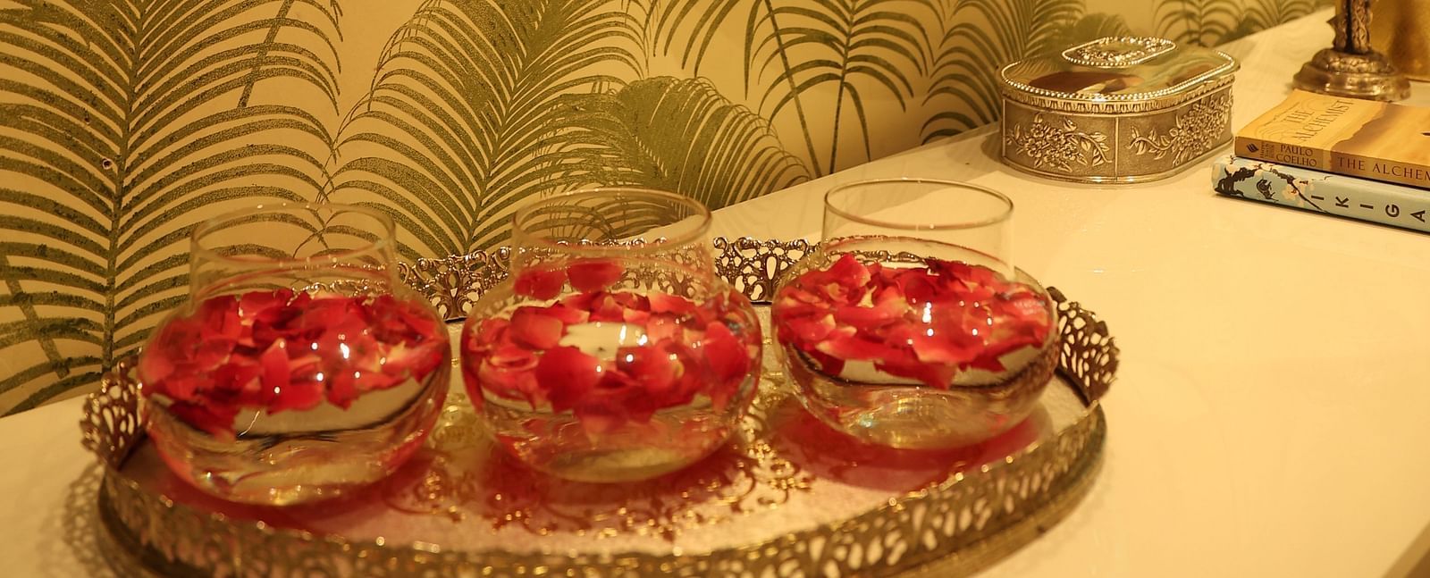 A view of decorative pieces placed on a table in front of a golden wall